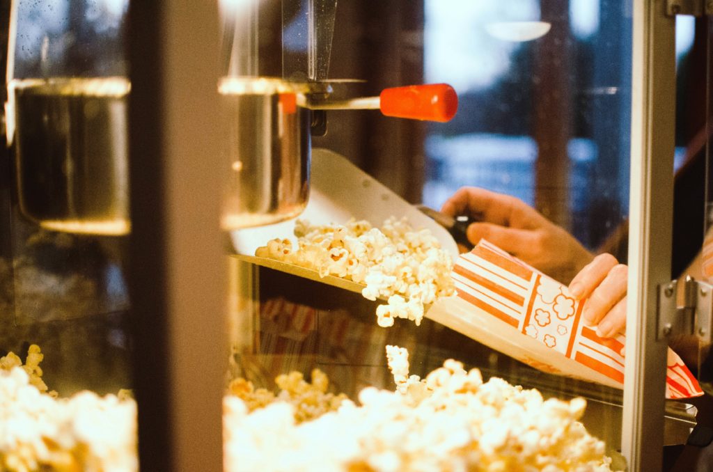A popcorn bucket being filled at the movie theater
