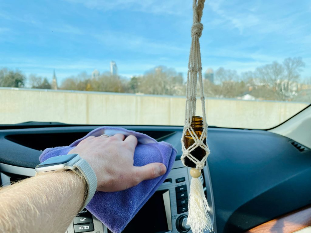 A man dusting the interior of his car
