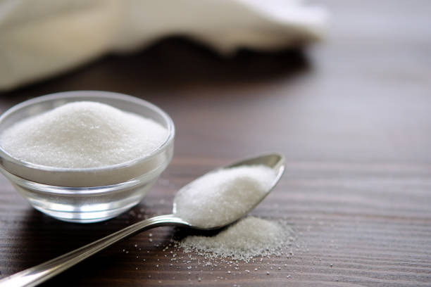 Natural seasoning, organic, sea, small and large, white salt in a spoon, in a cup, in a salt shaker, poured on a wooden table. Next to the linen towel. The concept of cooking healthy food, cosmetology, spa services, spa care.