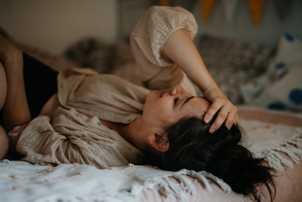 Portrait of a sad crying woman lying on bed.